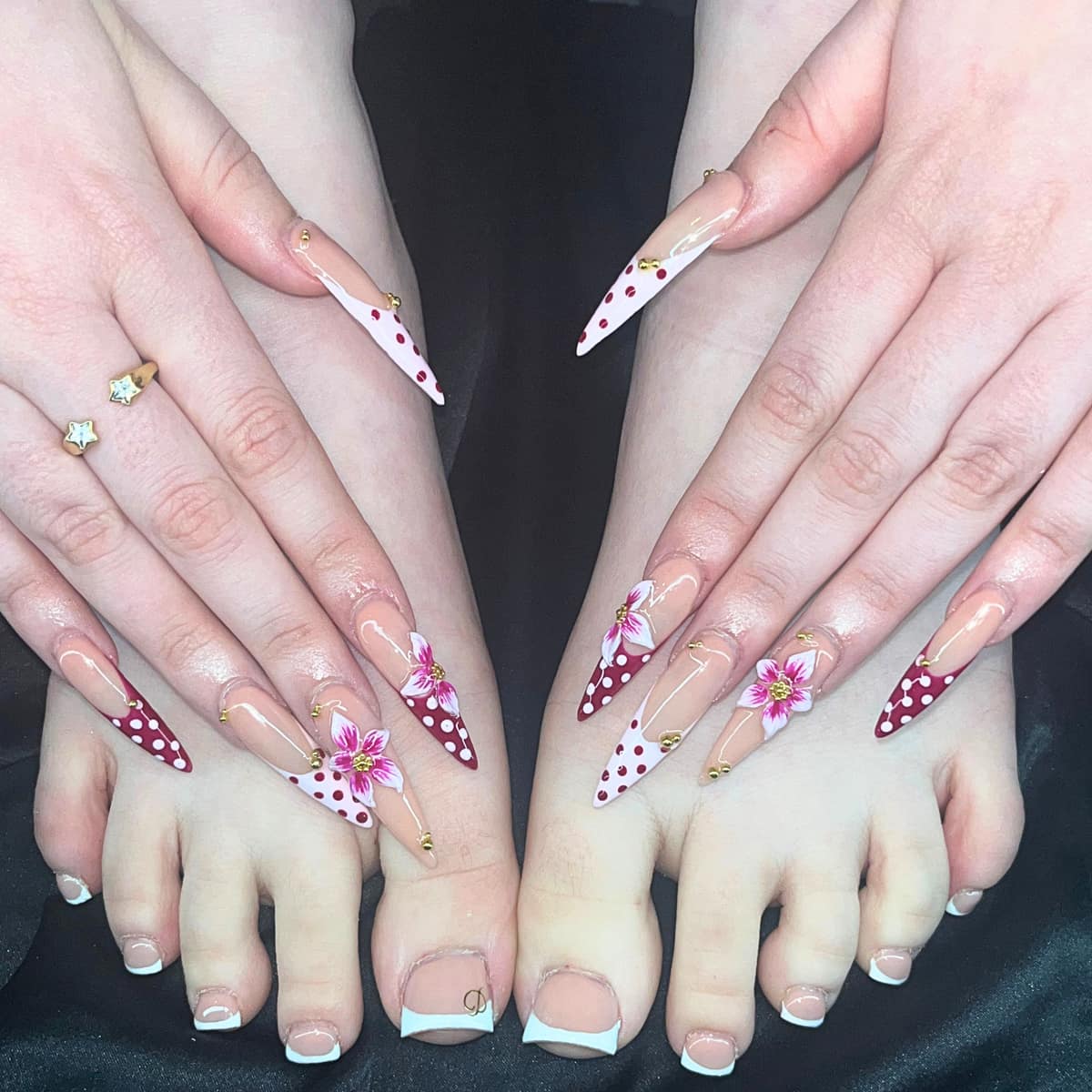 Matching set on hands and toes — red and white polka dots, hand-painted lilies, and white french toes.
