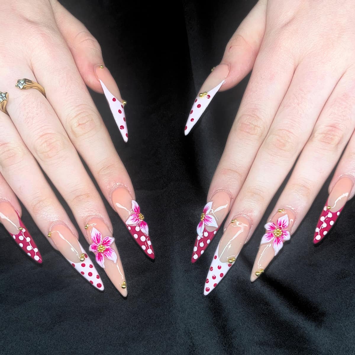 Full stiletto set in deep red and white polka dots with hand-painted pink lilies and gold beads.