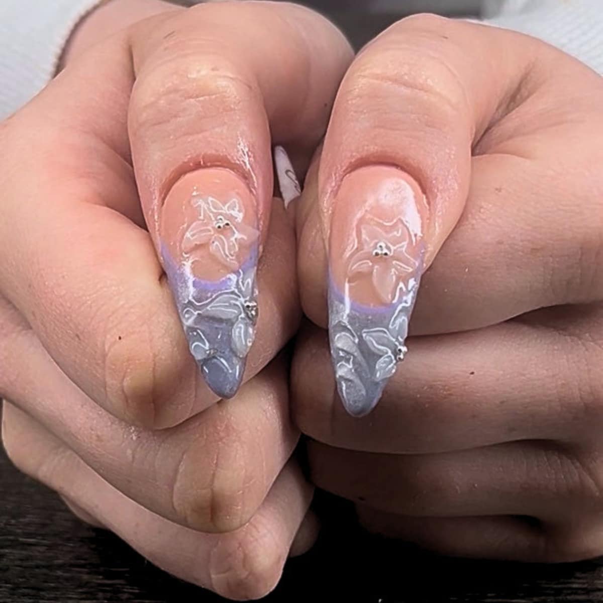 Almond tips in soft lilac with sculpted white petals and a silver bead centre.